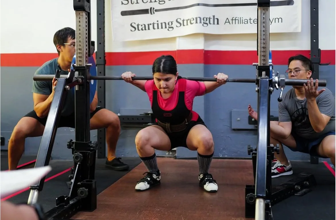 Riya mid-lift at a powerlifting competition